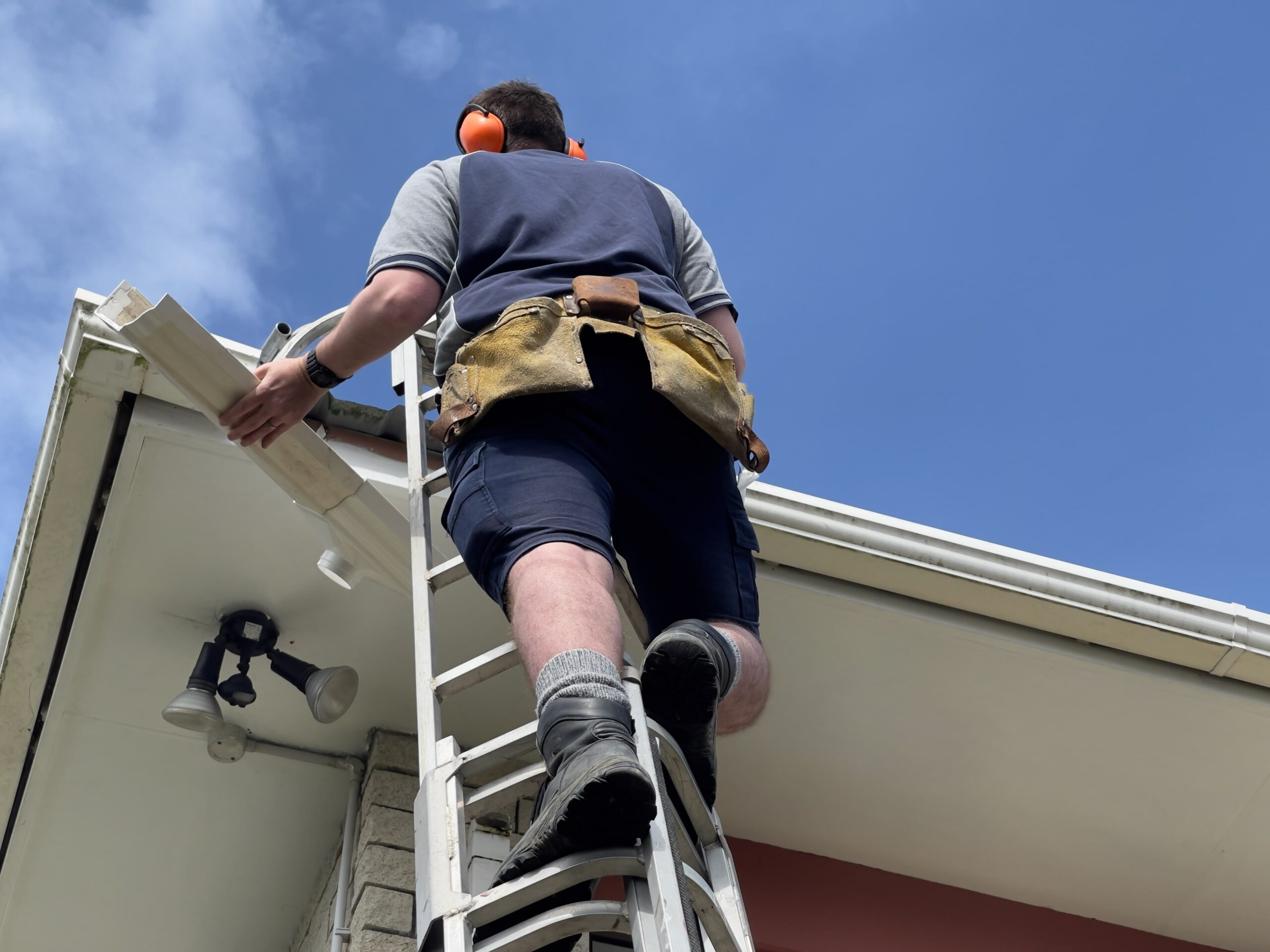 Castleton Service Group Contractor installing gutters on house roof Castleton Service Group Contractor installing gutters on house roof